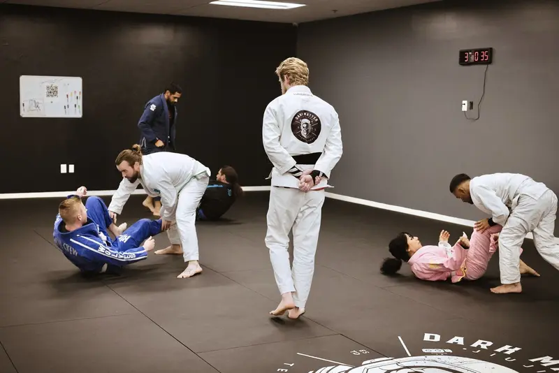 Coach Korey observing students drilling techniques during adult jiu-jitsu class at Dark Matter Jiu-Jitsu