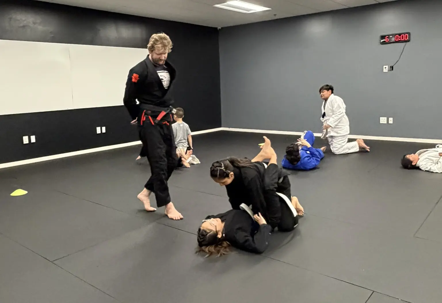 Kids rolling with coach supervising at Dark Matter Jiu-Jitsu near Gilbert AZ