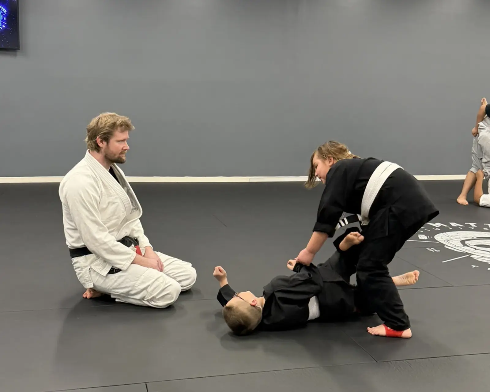 Kids jiu-jitsu sparring with coach at Dark Matter near Gilbert AZ